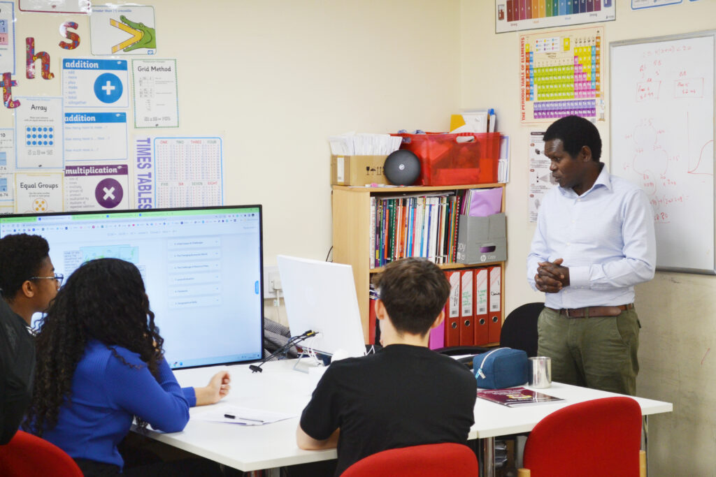 Dedicated instructor from PalTutors discussing a topic with attentive students in a well-organised classroom setting.