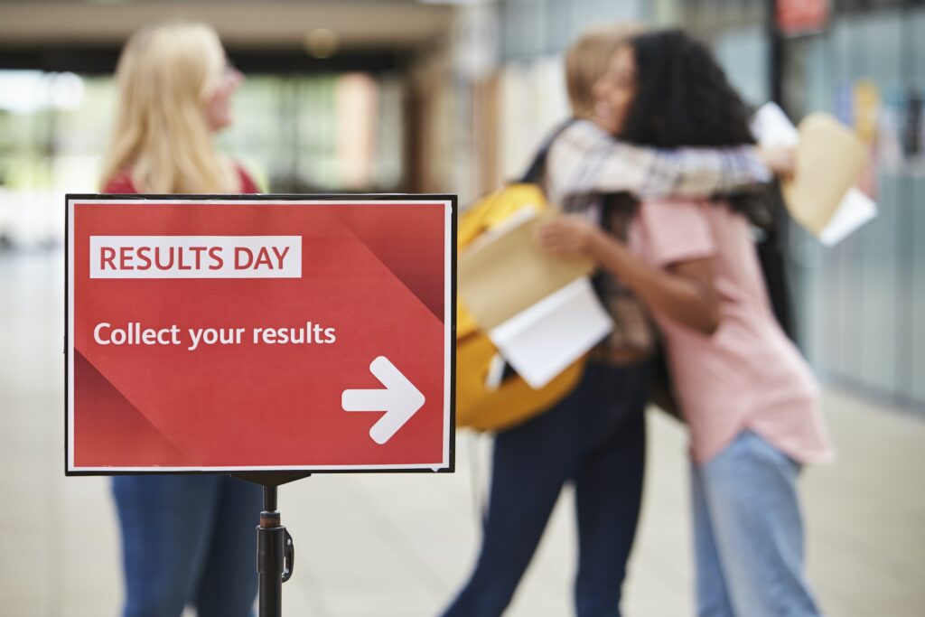 Students celebrating behind 'RESULTS DAY' sign after successful tutoring at PalTutors