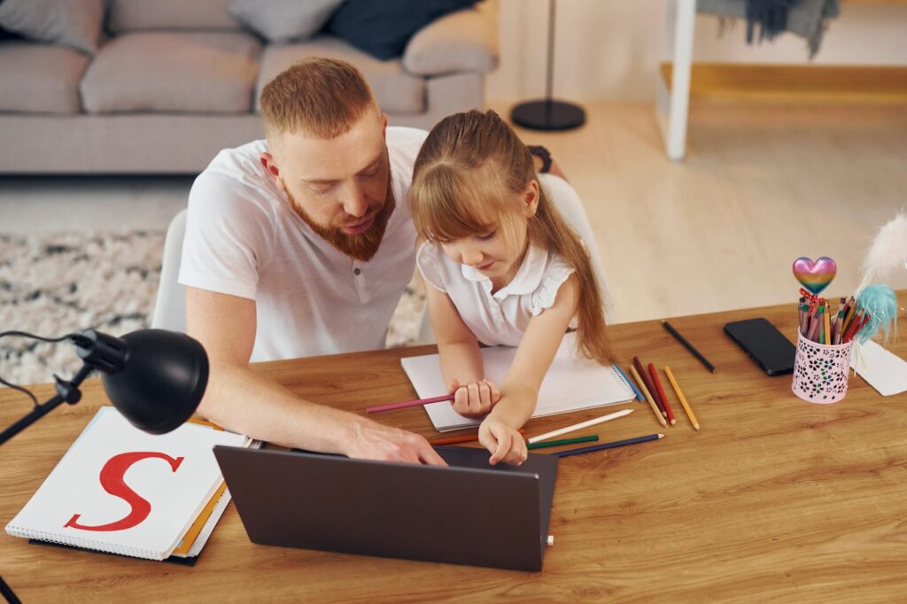 Online learning. Father with his little daughter is at home together