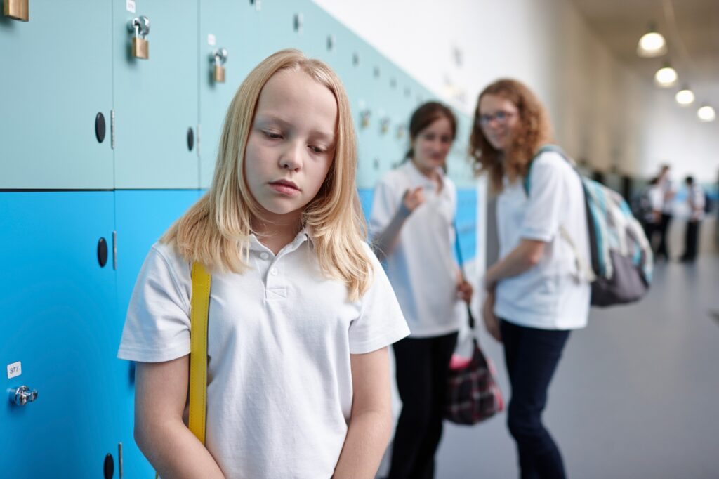 Schoolgirl being bullied in school corridor